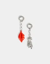 Set de dos charms intercambiables con diseño asimétrico: uno con forma de labios rojos y otro con forma de zapatillas de ballet plateadas con moño.