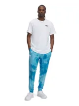 Pantalón de jogging Under Armour RVL Terry AOP para hombre, con estampado tie-dye en tonos celeste y azul.