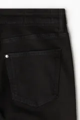 Pantalón de jean negro, de corte recto, con bolsillos delanteros y traseros.