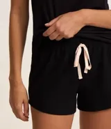 Pijama de dos piezas, compuesto por una remera de viscosa negra con estampado de leopardo y un short negro con lazo en la cintura.