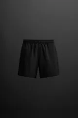 Shorts de entrenamiento negros confeccionados en tejido técnico ligero y elástico, con cintura elástica ajustable con cordón interior, bolsillos frontales y bolsillo trasero con cierre de cremallera. Bajo con acabado termofijado y aberturas laterales.