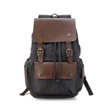 Mochila negra de tela canvas con detalles en símil cuero marrón, cierre superior marinero, bolsillos internos y externos con cierre metálico, asas rígidas y correas ajustables.