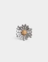 Anillo plateado con forma de margarita y centro dorado.