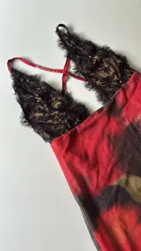 Minivestido con estampado floral en tonos rojos y negros, con escote halter de encaje negro.