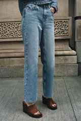 Jeans tobilleros de tiro alto, corte recto, color azul denim con cinco bolsillos y cierre frontal con cremallera y botón metálico.