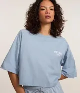 Remera corta celeste de algodón con estampado en la espalda con texto en blanco.