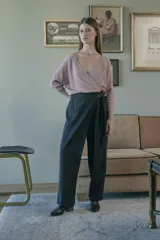 Pantalón negro de tiro medio con cierre lateral y pierna ancha. Presenta un lazo cruzado en la parte delantera.