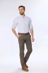 Pantalón de vestir color verde oliva, de corte recto, con bolsillos laterales y traseros. Se ajusta a la cintura con cinturón de cuero marrón.