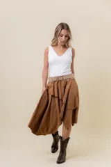 Pollera corta asimétrica de gamuza color marrón, con volados superpuestos y cintura elastizada. Incluye short interno.