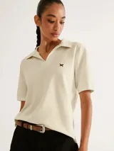 Camiseta color amarillo claro, de manga corta y cuello polo con escote en V.