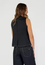 Chaleco beige de lino con escote en V, cierre frontal con botones y terminaciones desflecadas.