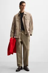 Pantalón de hombre color beige, corte carrot fit, con cintura elástica ajustable con cordón, bolsillos frontales y bolsillo trasero de plastrón.