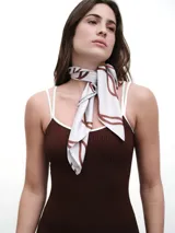 Pañuelo de seda con estampado que evoca ondas del mar, en tonos blanco y marrón.