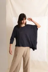 Poncho asimétrico color negro, de mangas 3/4, confeccionado en tela de lino.