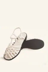 Sandalia de cuero trenzado multicolor, con diseño artesanal y cierre lateral con hebilla.