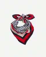 Pañuelo cuadrado grande de seda, con estampado de lunares blancos sobre fondo negro y borde con diseño geométrico en rojo, blanco y negro.