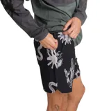 Bermuda negra con estampado de serpientes, soles y cactus en blanco. Confeccionada en poliéster reciclado REPREVE® con acabado DWR resistente al agua. Incluye bolsillos laterales, trasero con cierre YKK y lateral con cierre.