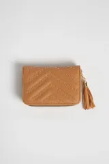 Billetera color tostado con diseño capitoneado en forma de V y tachas doradas. Cierre con cremallera y detalle de borla en el lateral.