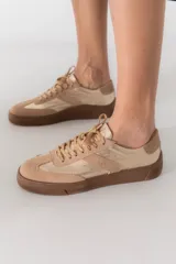 Zapatillas bajas color verde militar de gamuza con suela marrón y detalle trasero en color crema.