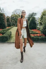 Tapado marrón de cuero con corte a la rodilla, mangas largas y aberturas laterales.