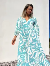 Vestido largo de corte amplio, con estampado abstracto en tonos verde agua y crudo. Tiene escote en V con lazos y mangas largas abullonadas.