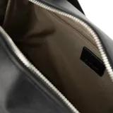 Cartera tipo baúl color negro, confeccionada en símil cuero graneado. Tiene doble asa de mano y correa bandolera regulable y extraíble. El acceso es con cierre y cuenta con un bolsillo interno con cierre y dos abiertos. El interior es de tela de algodón y poliéster.