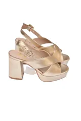 Sandalias de plataforma Cherie en cuero dorado metalizado. Diseño elegante con tiras cruzadas, pulsera ajustable al tobillo y tacón de bloque alto de aproximadamente 10 cm combinado con una plataforma delantera.
