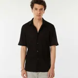 Camisa negra de manga corta con tejido de punto calado, cuello clásico y cierre frontal con botones.