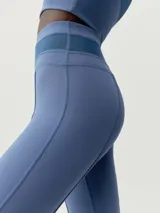 Calza larga acampanada color negro, de tejido Skin_Move ligero y resistente. Cinturilla ancha doble tejido y pieza decorativa en tejido de malla transpirable.