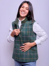 Chaleco verde con diseño a cuadros en tonos rosa y amarillo, con cuello y ribetes en verde liso. Cierre frontal con cremallera y bolsillos laterales.