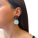 Aros colgantes de resina rosa con piezas geométricas y ajuste de perforación en acero hipoalergénico.