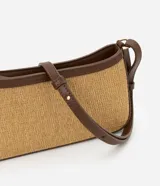 Cartera baguette color beige con efecto paja y detalles en cuero sintético marrón. Tiene correa de hombro ajustable y cierre por cremallera.