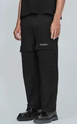 Pantalón cargo negro de corte recto con bolsillos laterales con solapa y detalle de etiqueta con texto en blanco.