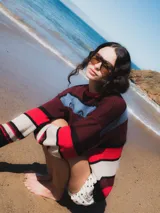 Sweater tejido a rayas horizontales en tonos borgoña, rojo, crema, negro y celeste.