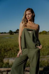 Conjunto de top y pantalón color beige. El top es de breteles anchos, con detalle en dos colores y un bordado en su delantera. El pantalón es liso, de corte recto ancho con bolsillos a los costados y cintura con botones y elástico.