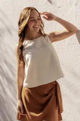 Blusa sin mangas color crema, de corte holgado y confeccionada en lino y algodón.