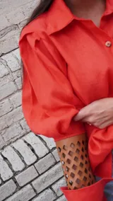 Camisa color naranja de lino con mangas abuchonadas y detalle calado en los puños.
