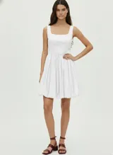 Vestido corto blanco de corte evasé, con escote cuadrado y tirantes anchos.