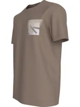 Remera color marrón claro de corte recto y mangas cortas. Presenta un bolsillo en el pecho con el monograma de Calvin Klein Jeans enmarcado en una caja.