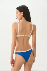 Tanga de bikini azul con ribete color crema.