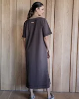 Vestido midi negro con cuello redondo y mangas cortas. Presenta dos bolsillos cuadrados en el pecho y ribetes blancos en cuello, mangas, bolsillos y ruedo.