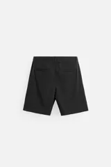 Bermuda negra regular fit confeccionada en tejido con mezcla de algodón y lino. Cintura elástica ajustable con cordón. Pliegues frontales. Bolsillos laterales y traseros de vivo. Cierre frontal con cremallera y botón.