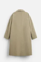 Gabardina color beige de corte amplio, con cuello solapa, manga larga, bolsillos laterales con solapa y cierre frontal con botones.