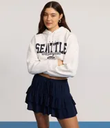 Short pollera de viscosa color azul marino, con cintura elástica y lazo ajustable, con diseño de volados superpuestos.