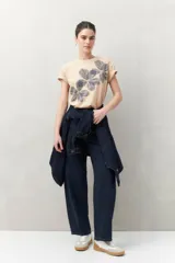 Remera blanca de manga corta con estampado floral en tonos dorados en el frente.