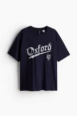 Remera azul marino de corte amplio con estampado de la palabra Oxford y un escudo.