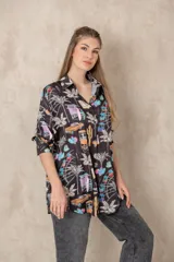 Camisa larga estampada con diseño de palmeras y elementos gráficos, de manga larga y corte holgado.