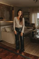 Remera negra de punto canalé con escote cruzado en V y mangas largas con puños de piel sintética con pelo.