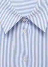 Camisa celeste y blanca a rayas verticales, de corte recto y mangas largas con puños abotonados.