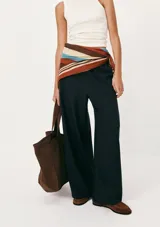 Pantalón de lino color crema, de corte recto y tiro alto, con cintura elástica ajustable con cordón y bolsillos laterales.